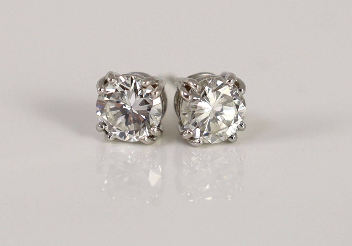 A pair of white gold and solitaire diamond set ear studs